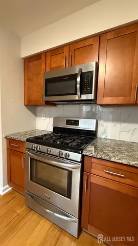 a kitchen with stainless steel appliances granite countertop a stove and a microwave