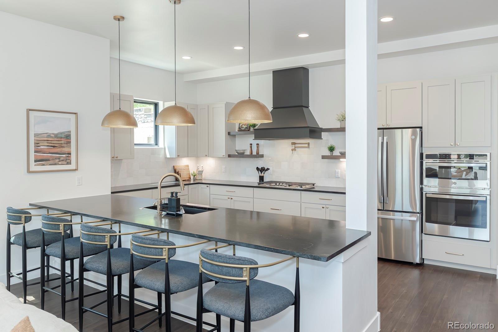 175 Whistlestop Circle Winter Park, CO 80482 - Photo 14 of 36 a kitchen with stainless steel appliances granite countertop a stove a refrigerator a oven a sink with a dining table and chairs