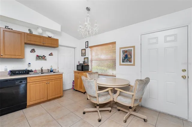 a kitchen with stainless steel appliances granite countertop a sink dishwasher a stove a refrigerator dining table and chairs with wooden floor