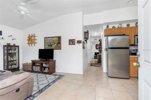 a kitchen with a refrigerator and a flat screen tv