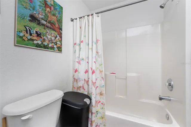a bathroom with a toilet and a shower curtain