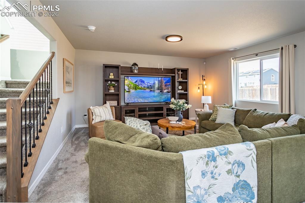 7751 Berwyn Loop Peyton, CO 80831 - Photo 12 of 50 a living room with furniture a rug and a flat screen tv