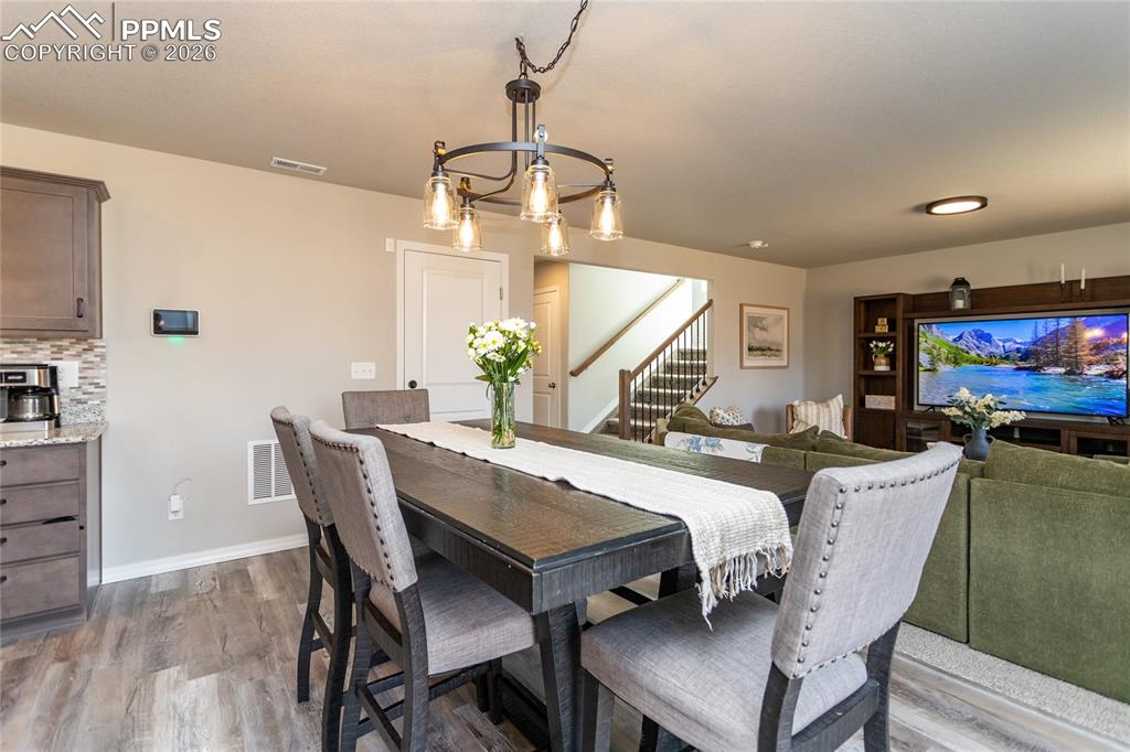 7751 Berwyn Loop Peyton, CO 80831 - Photo 16 of 50 a view of a dining room with furniture a chandelier and wooden floor