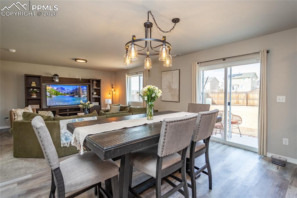 7751 Berwyn Loop Peyton, CO 80831 - Photo 17 of 50 a dining room with furniture a chandelier and wooden floor