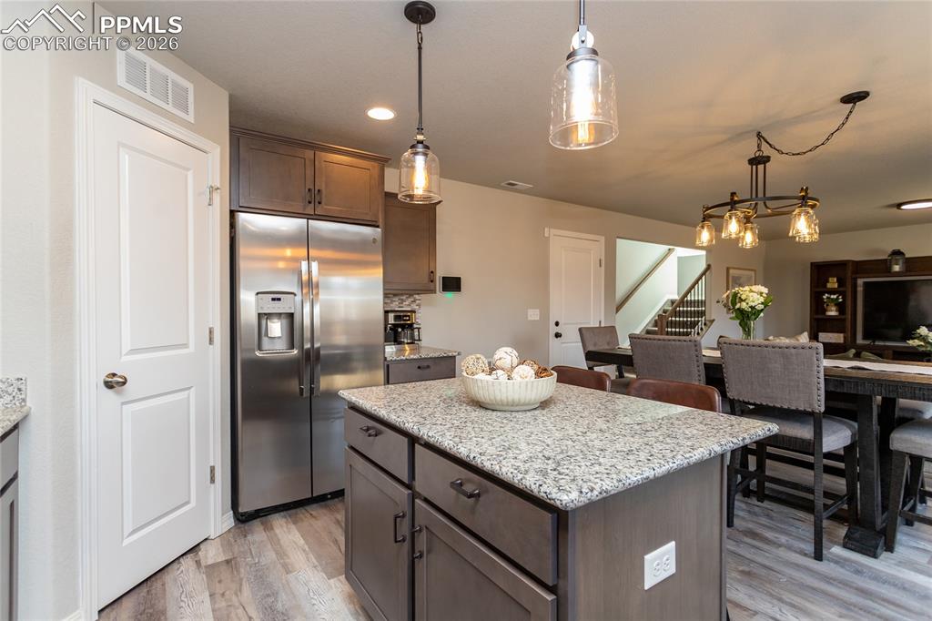 7751 Berwyn Loop Peyton, CO 80831 - Photo 21 of 50 a kitchen with center island table and chairs in it