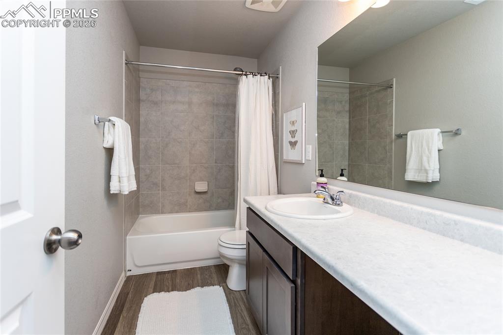 7751 Berwyn Loop Peyton, CO 80831 - Photo 30 of 50 a bathroom with a sink a toilet a mirror a bathtub and shower