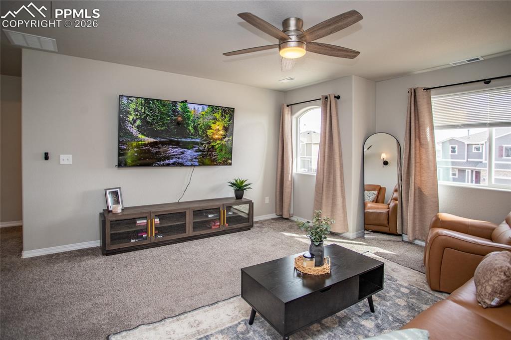 7751 Berwyn Loop Peyton, CO 80831 - Photo 35 of 50 a living room with furniture a large window and a flat screen tv