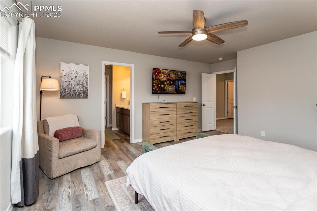 7751 Berwyn Loop Peyton, CO 80831 - Photo 39 of 50 a spacious bedroom with a bed a couch and a chandelier