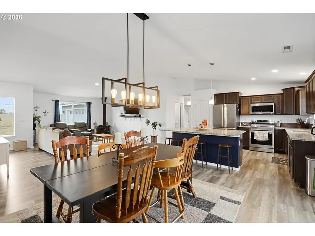 a view of kitchen with kitchen island dining table and stainless steel appliances
