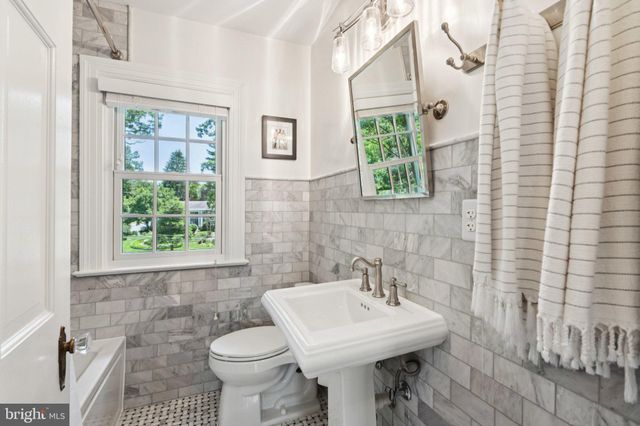 a bathroom with a toilet a sink a vanity and mirror