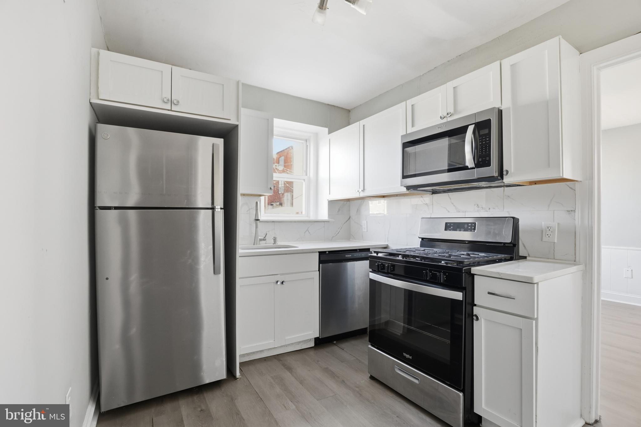 831 North 10th Street Reading, PA 19604 - Photo 14 of 33 a kitchen with cabinets stainless steel appliances and wooden floor