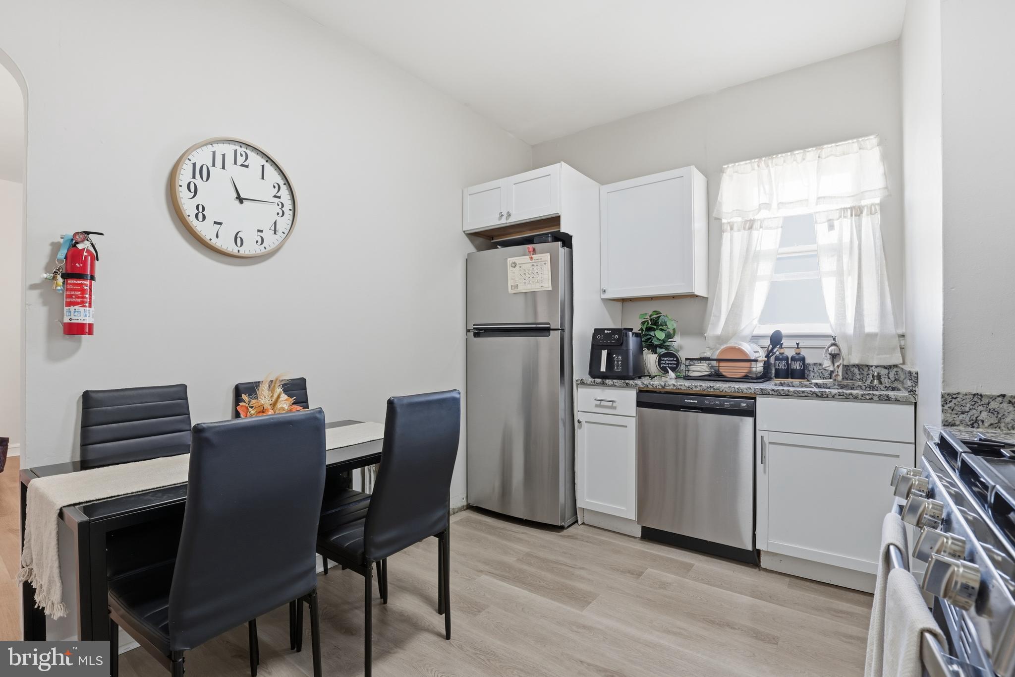 831 North 10th Street Reading, PA 19604 - Photo 26 of 33 a kitchen with stainless steel appliances granite countertop a dining table chairs cabinets a large window and a refrigerator