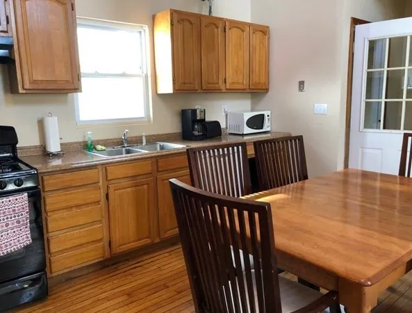 a kitchen with stainless steel appliances granite countertop a stove a sink dishwasher and cabinets with wooden floor