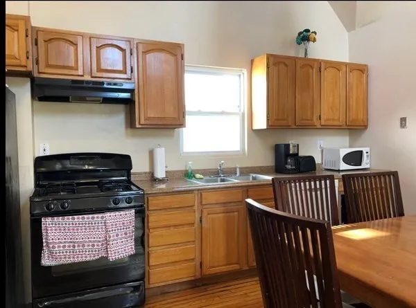 a kitchen with stainless steel appliances granite countertop a stove a sink and a microwave