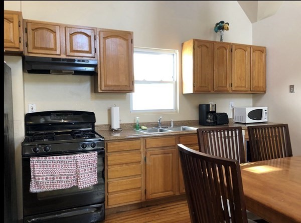 138 Ferry Street, Unit 2 Everett, MA 02149 - Photo 6 of 18 a kitchen with stainless steel appliances granite countertop a stove a sink and a microwave