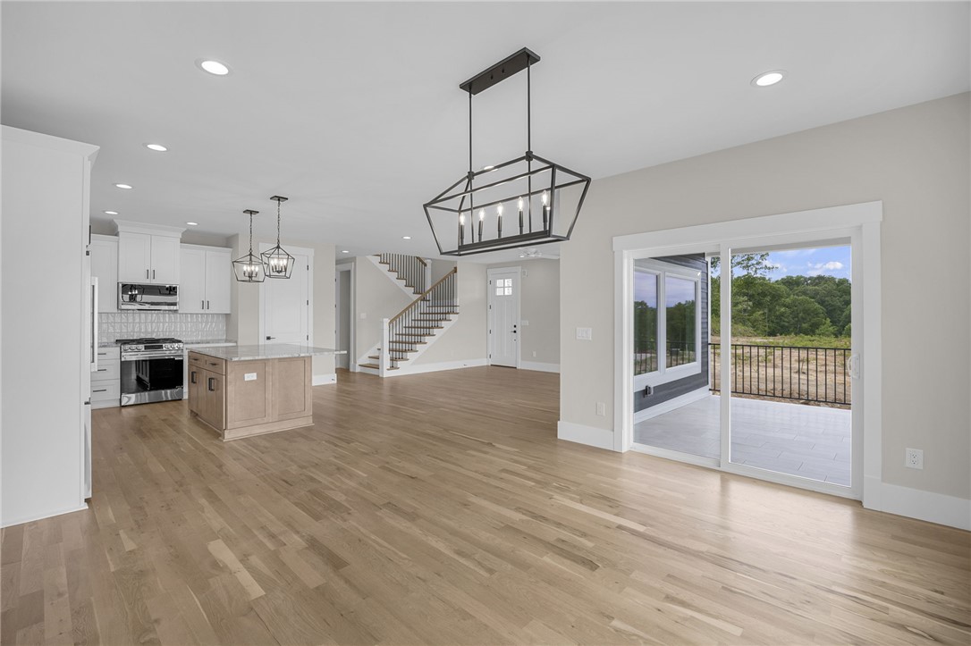 1230 Melton Road, Unit 216 West Union, SC 29696 - Photo 3 of 49 An open-concept living space with hardwood floors, a modern kitchen, and a sliding glass door leading to a scenic outdoor patio.