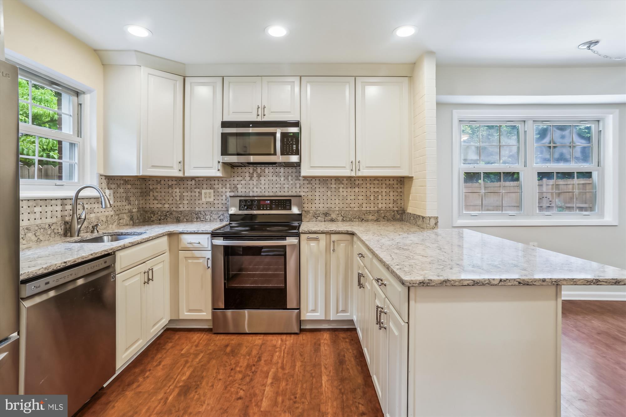 3909 Woodlawn Road Chevy Chase, MD 20815 - Photo 14 of 54 a kitchen with stainless steel appliances granite countertop a stove a sink and a microwave