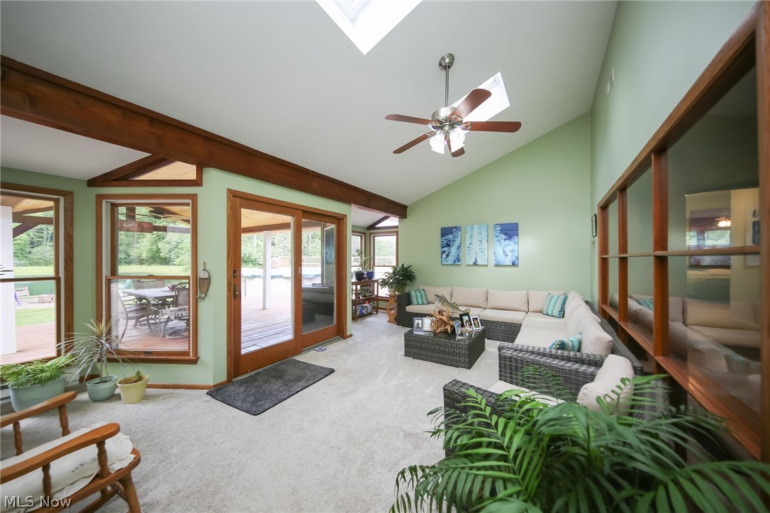 3362 Granger Road Medina, OH 44256 - Photo 9 of 49 Carpeted living room with high vaulted ceiling, beamed ceiling, ceiling fan, and a skylight