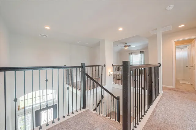 a view of a hallway with wooden floor and staircase
