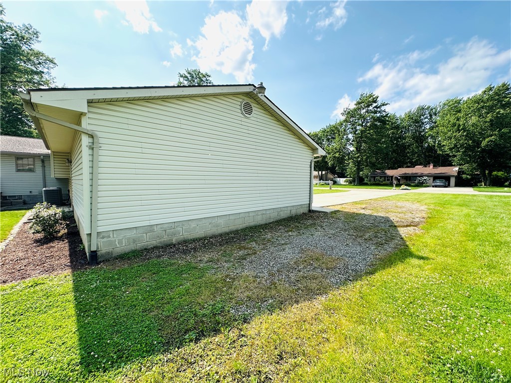 1684 Morris Street Mineral Ridge, OH 44440 - Photo 12 of 50 View of side of property featuring a yard and central AC unit