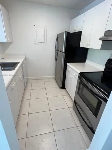 a kitchen with a stove a refrigerator and cabinets