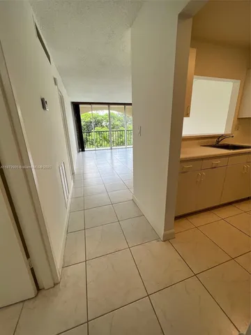 a view of a kitchen with furniture and an empty room
