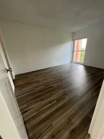 a view of room with window and wooden floor
