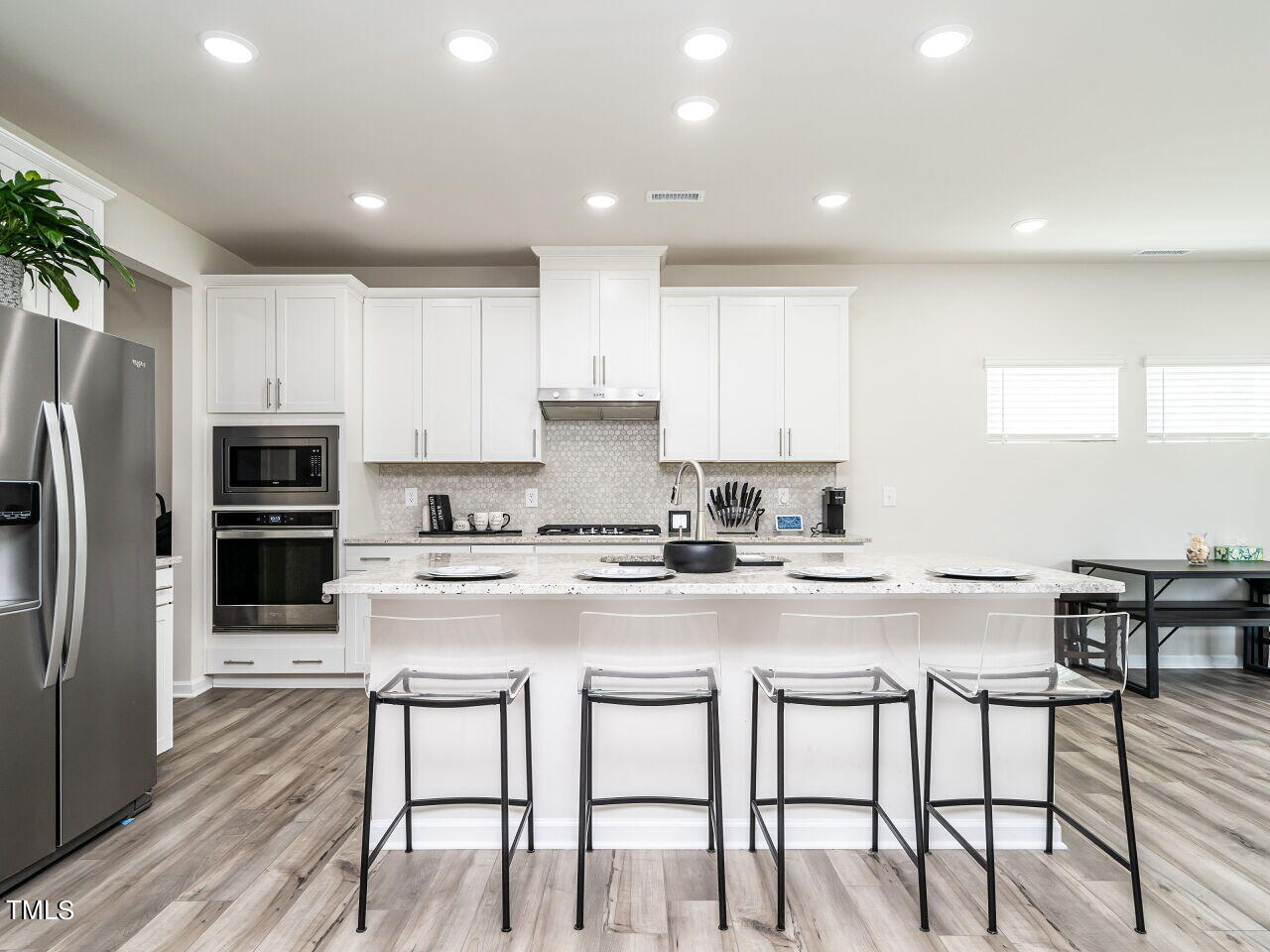 633 Embrun Run Wendell, NC 27591 - Photo 12 of 32 a kitchen with stainless steel appliances granite countertop a table and chairs in it