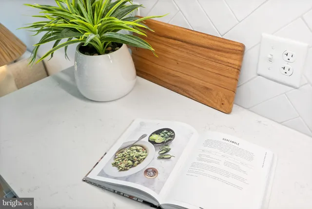 a kitchen with a stove a microwave a dining table and chairs with wooden floor