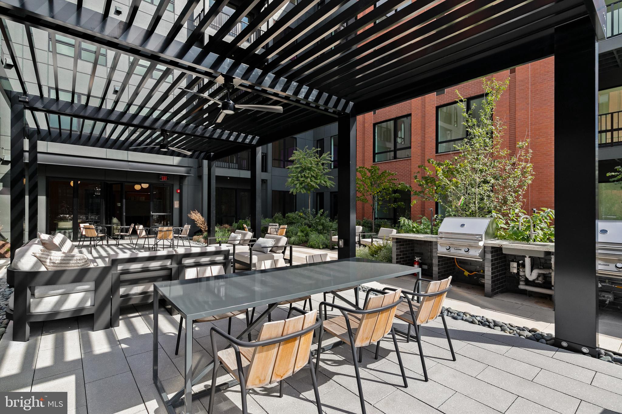 7175 12th Street Northwest, Unit 405 Washington, DC 20012 - Photo 49 of 63 a view of a patio with table and chairs and potted plants