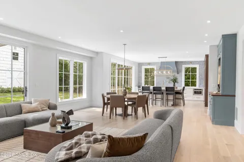 a living room with furniture wooden floor and a large window