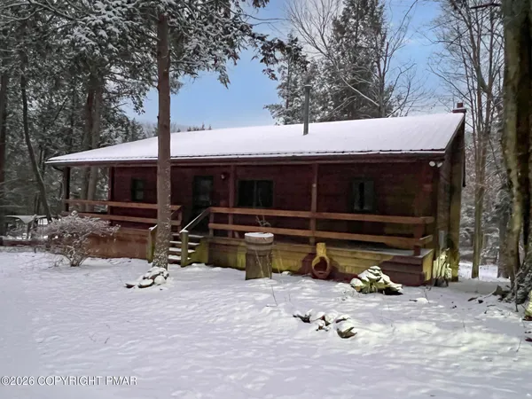 a view of house with backyard outdoor seating and covered with trees