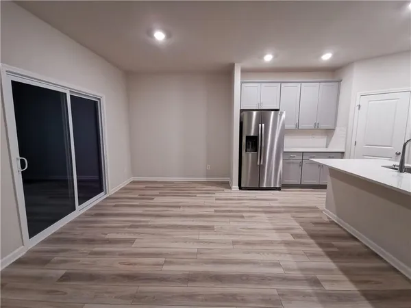 a view of kitchen with refrigerator microwave and wooden floor