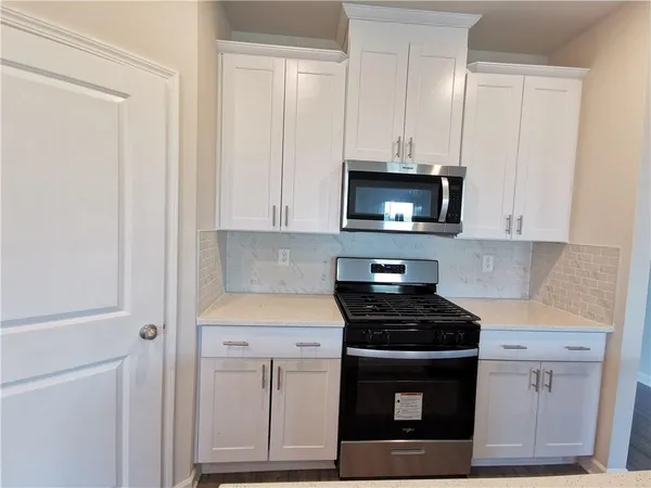 a kitchen with white cabinets and stainless steel appliances