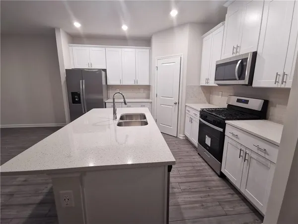 a kitchen with stainless steel appliances a refrigerator stove microwave and cabinets