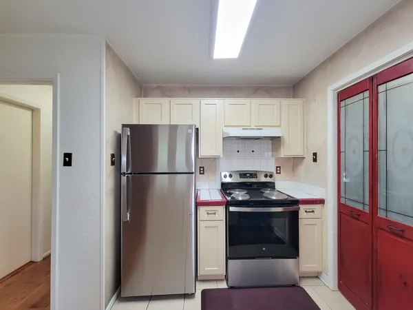 a kitchen with a refrigerator stove and white cabinets