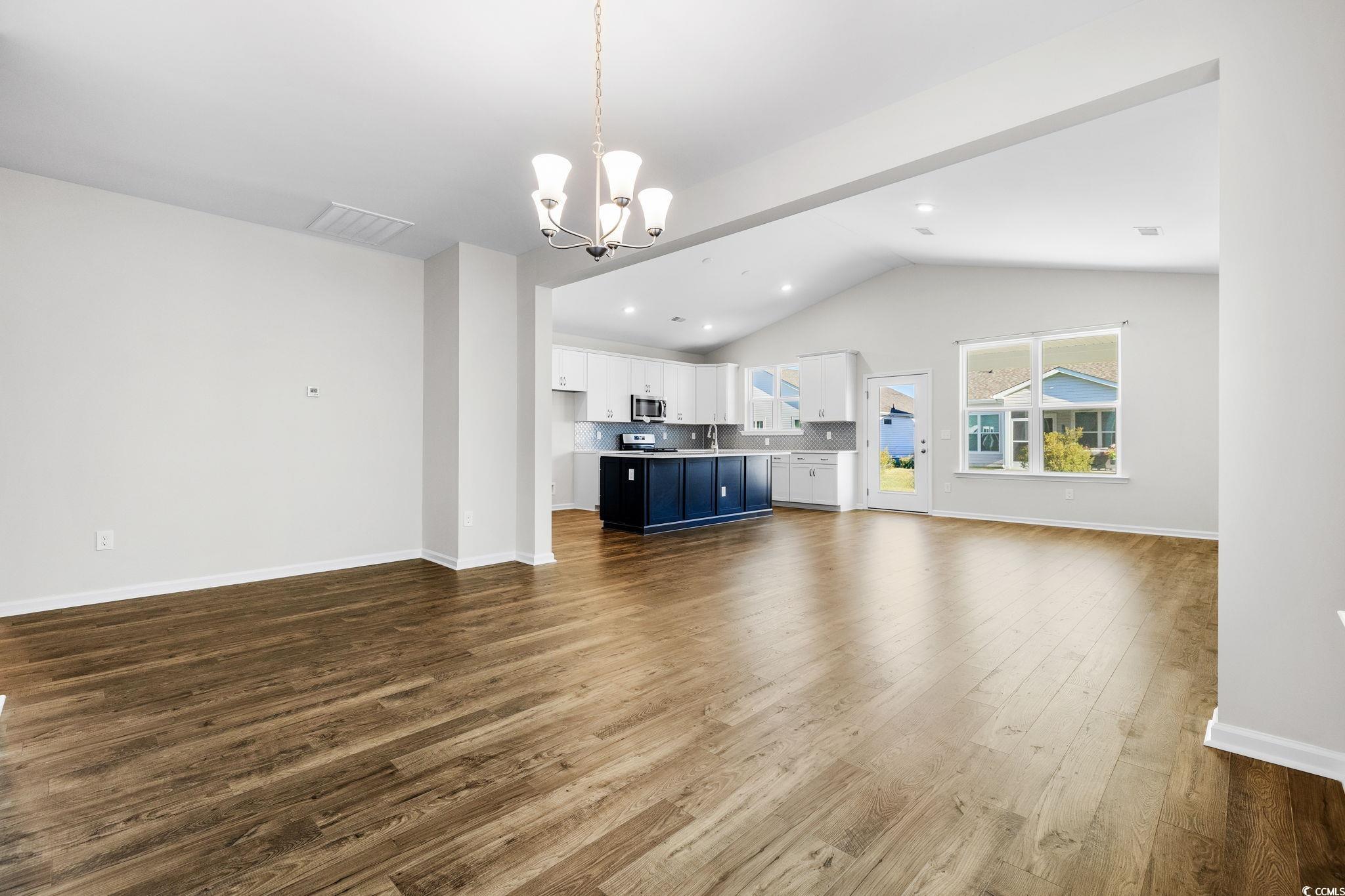 453 Kapalua Loop Little River, SC 29566 - Photo 10 of 27 Unfurnished living room with lofted ceiling, dark wood-style floors, a chandelier, and recessed lighting