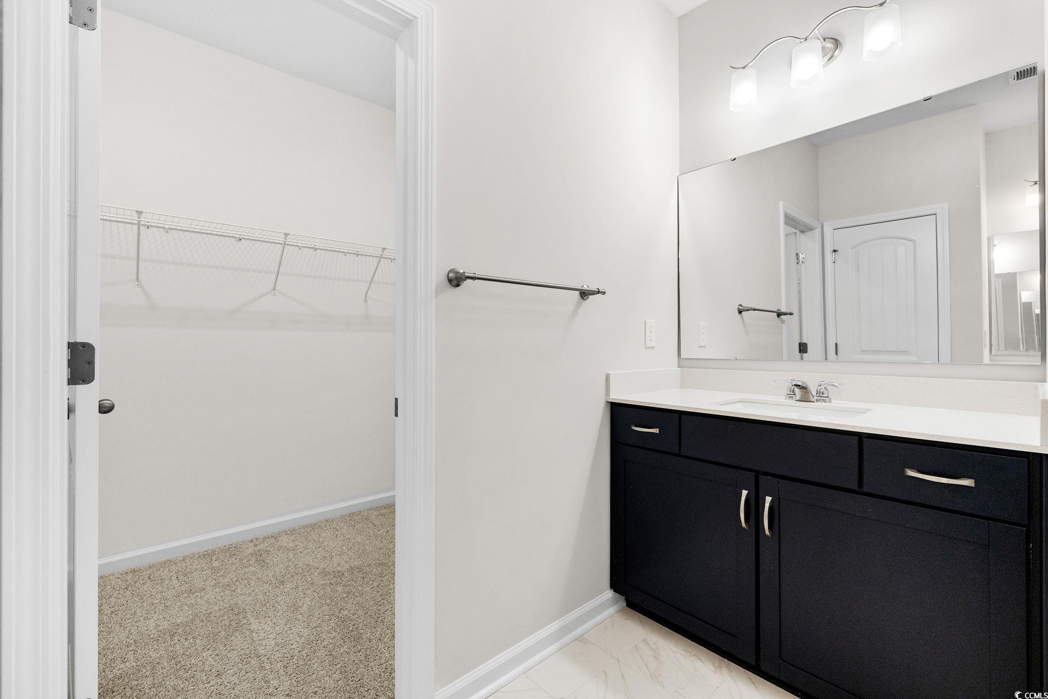 453 Kapalua Loop Little River, SC 29566 - Photo 15 of 27 Full bath featuring a walk in closet, vanity, and light colored carpet