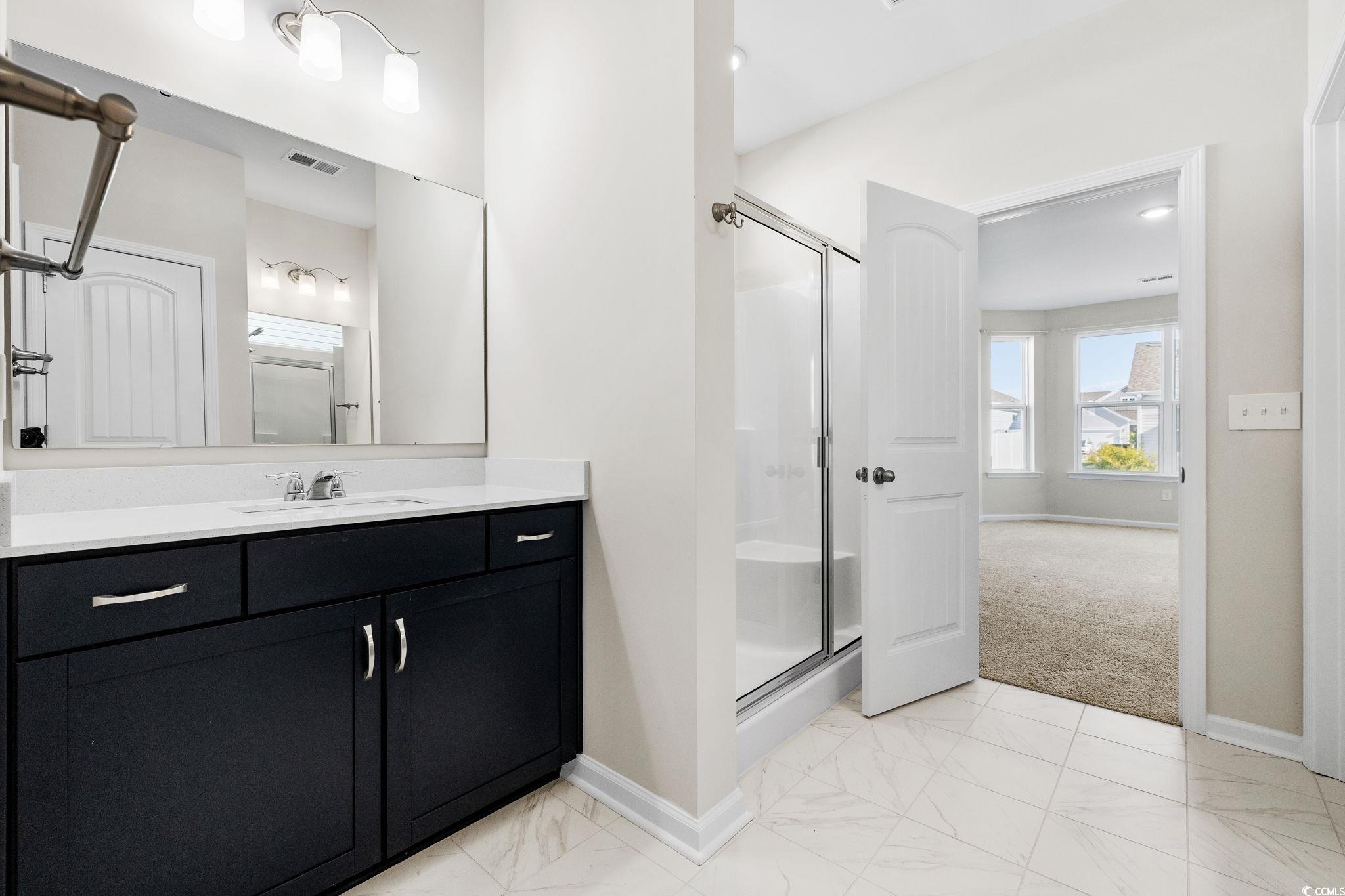 453 Kapalua Loop Little River, SC 29566 - Photo 16 of 27 Full bathroom with vanity, a shower stall, light marble finish flooring, and light colored carpet