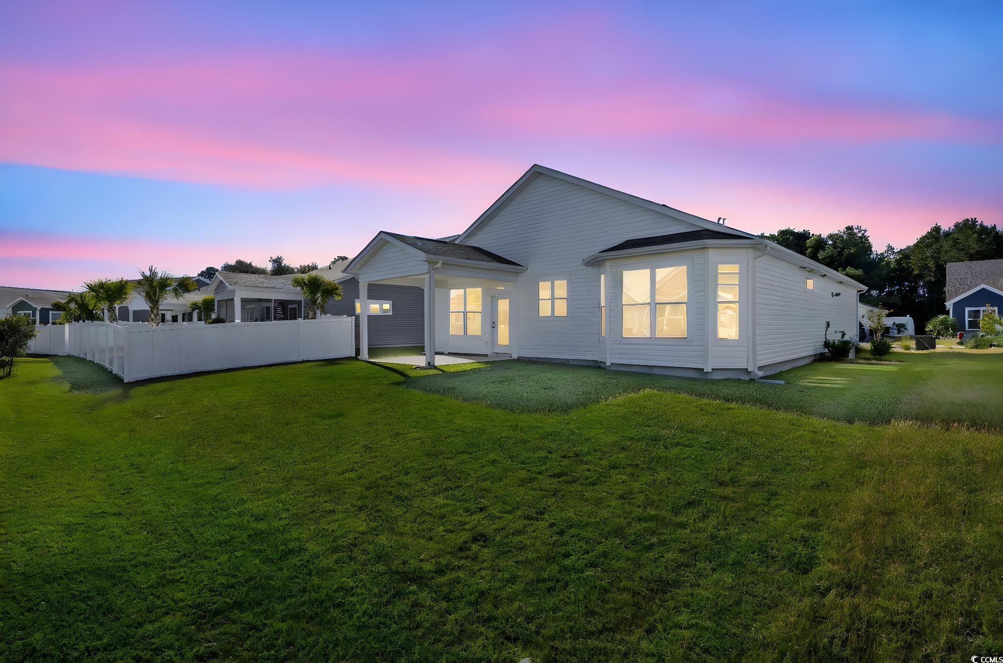 453 Kapalua Loop Little River, SC 29566 - Photo 23 of 27 Back of house at dusk featuring a patio