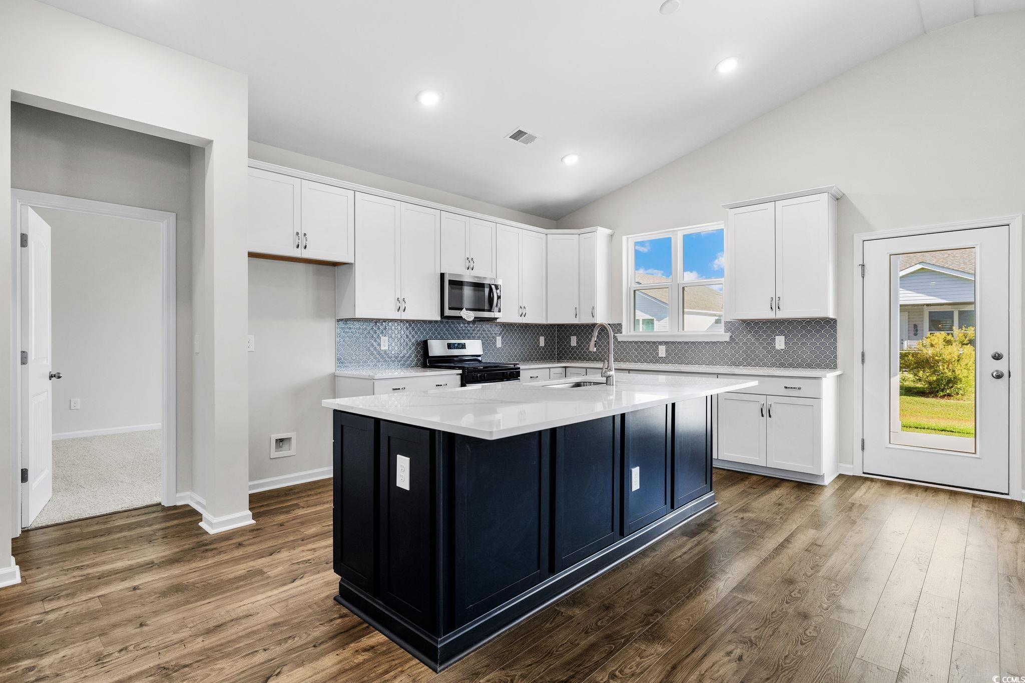 453 Kapalua Loop Little River, SC 29566 - Photo 5 of 27 Kitchen featuring white cabinets, dark wood-style flooring, decorative backsplash, recessed lighting, and lofted ceiling