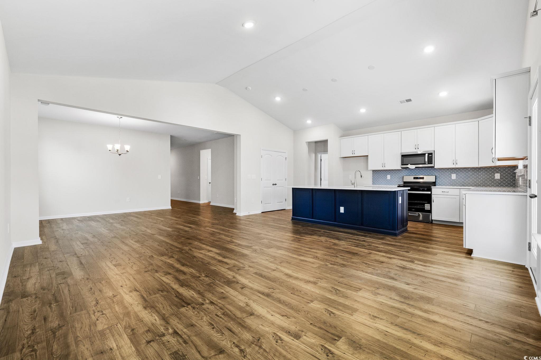 453 Kapalua Loop Little River, SC 29566 - Photo 26 of 27 Kitchen with white cabinetry, open floor plan, tasteful backsplash, stainless steel appliances, and dark wood-style flooring