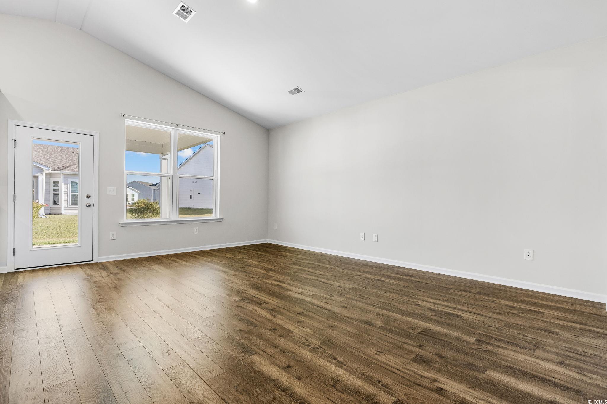 453 Kapalua Loop Little River, SC 29566 - Photo 9 of 27 Unfurnished room with dark wood-style flooring and vaulted ceiling