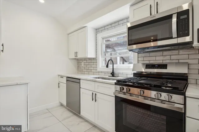 a kitchen with cabinets stainless steel appliances and a sink