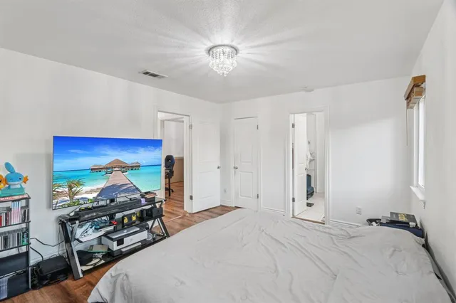 a bedroom with a bed and a wooden floor