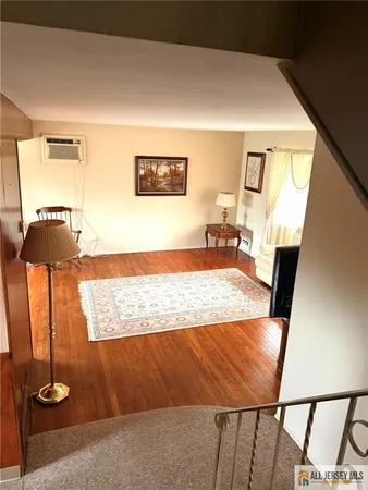 a view of a hallway to a livingroom with wooden floor
