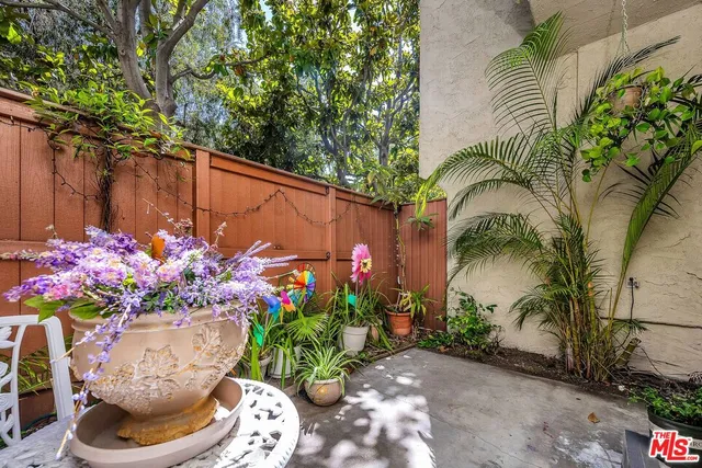 a vase with flowers sitting on a patio