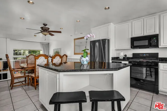 a kitchen with granite countertop a sink appliances and cabinets