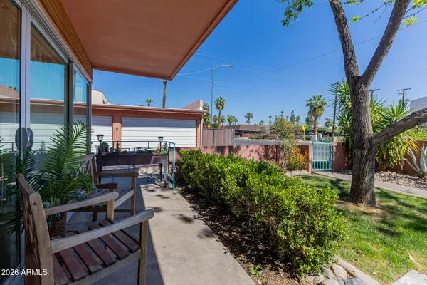 a view of a patio with table and chairs potted plants and palm tree