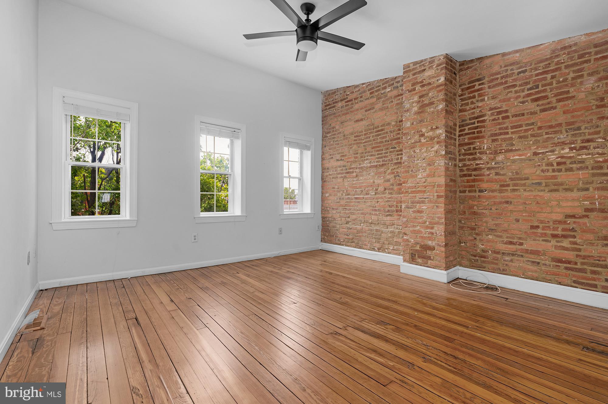 1329 South Charles Street Baltimore, MD 21230 - Photo 13 of 30 a view of an empty room with wooden floor and a window